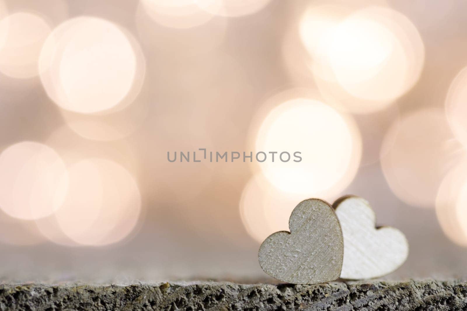 Two handmade wooden hearts on beautiful golden bokeh background. Vintage style. Love Valentine's Day concept.