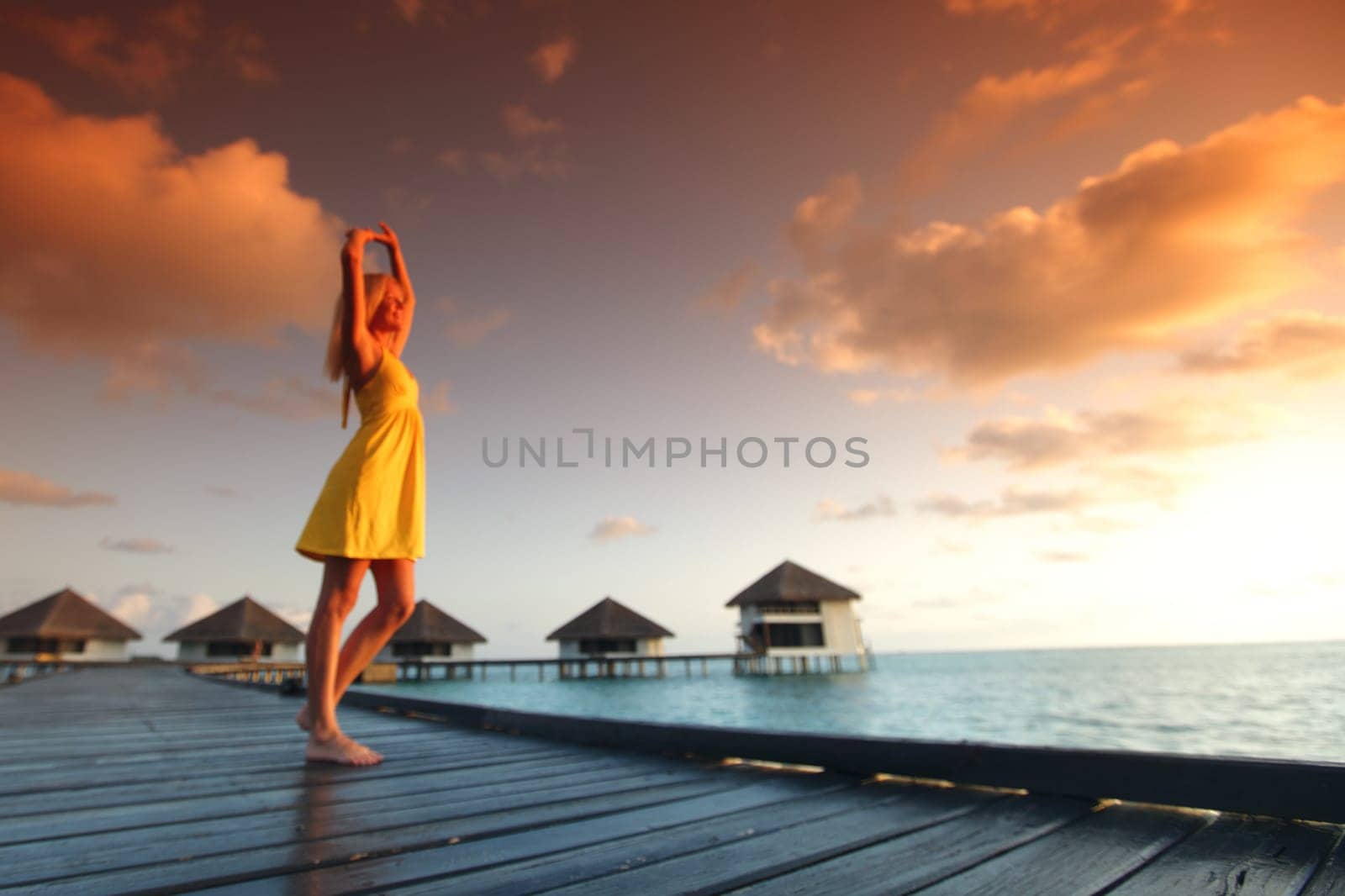 woman in a dress on maldivian sunset by Yellowj