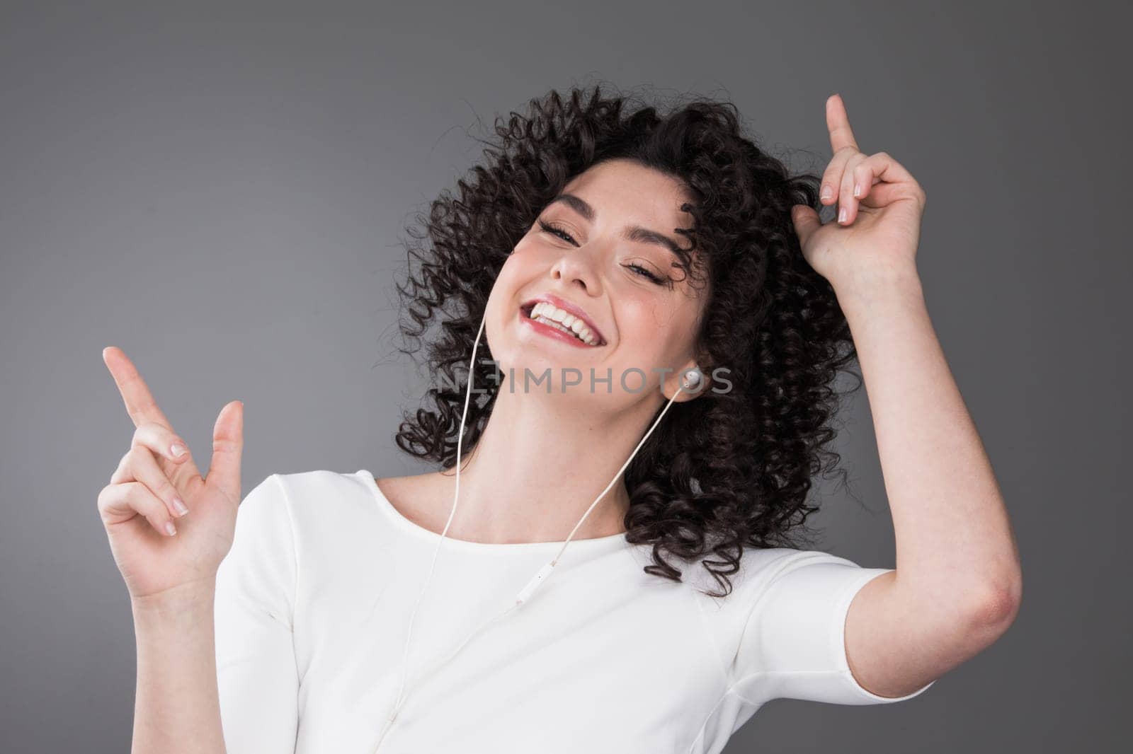 Young woman listening music in earphones by Yellowj