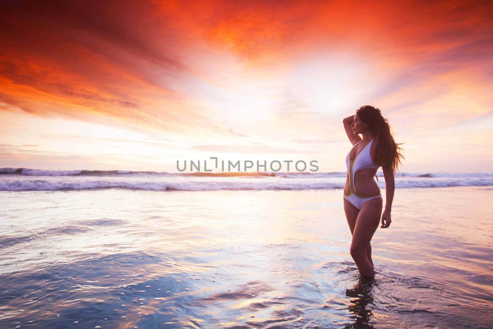 Pretty slim girl at the beach at sunset summer vacation