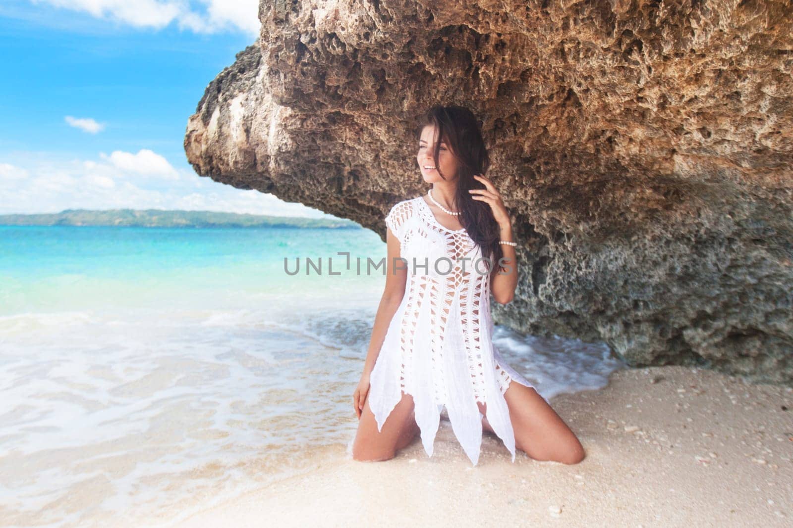 Woman on white boho dress posing on sea beach in Thailand