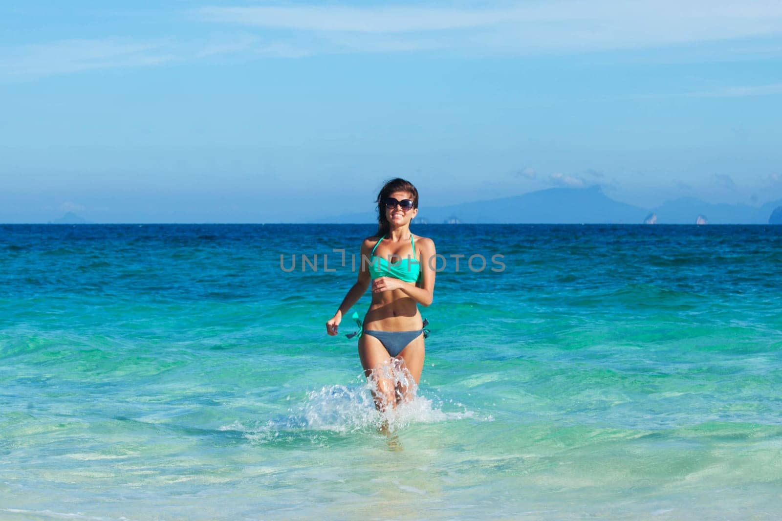 Beautiful fit woman in bikni run to tropical beach