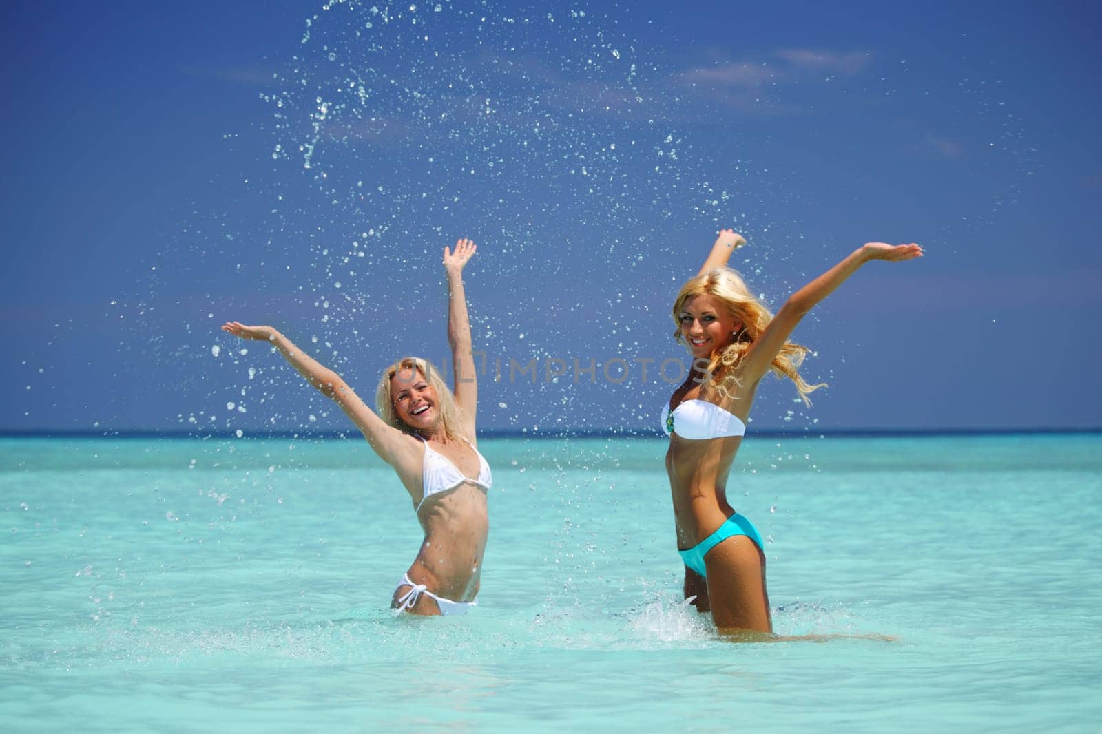 Two girls playing in ocean water