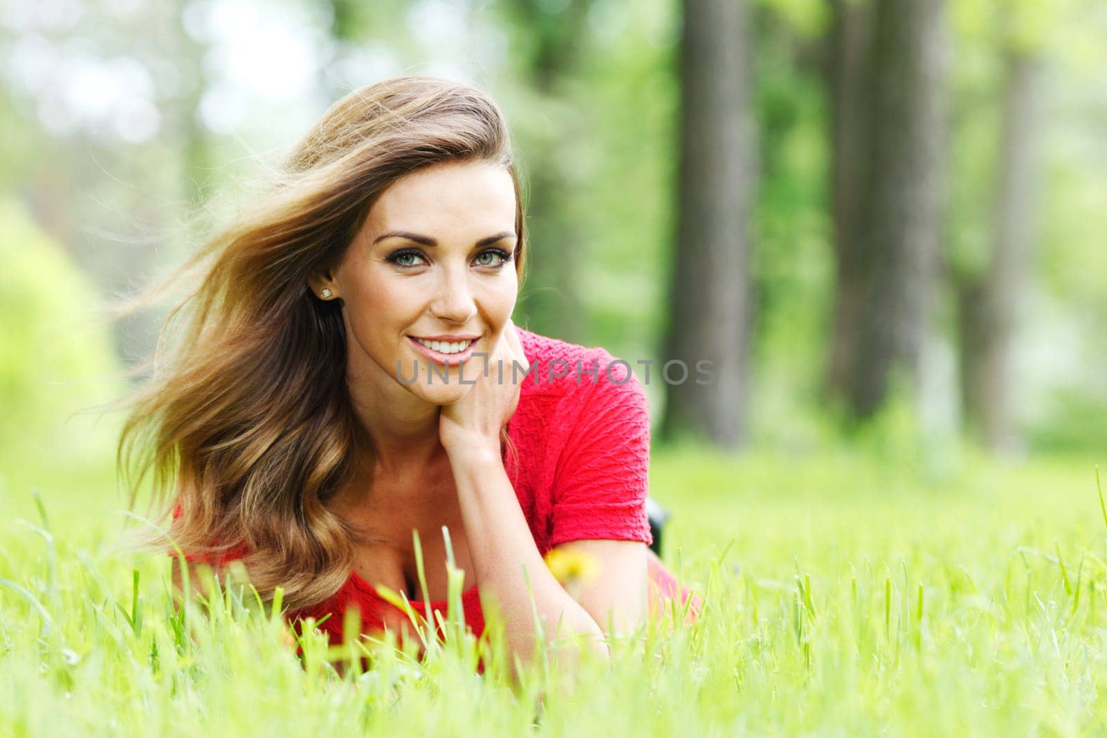 young woman in red dress lying on grass by Yellowj