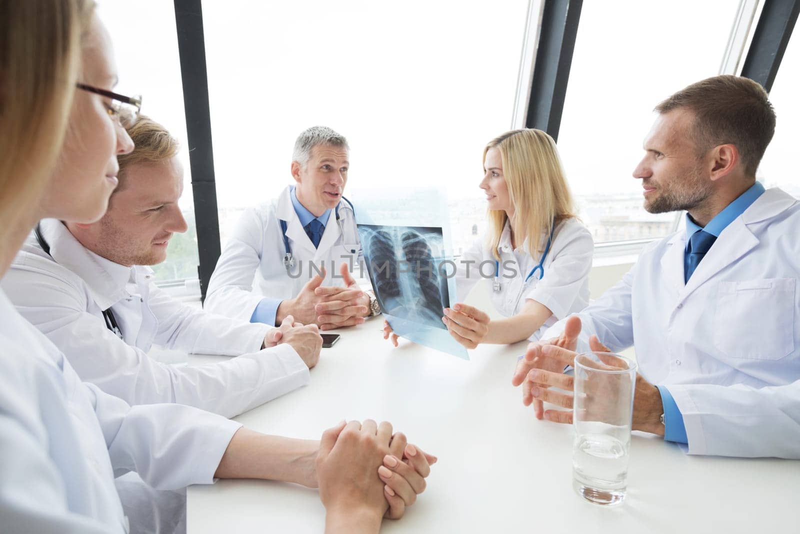 Team of experts doctors examining mri report on hospital office meeting
