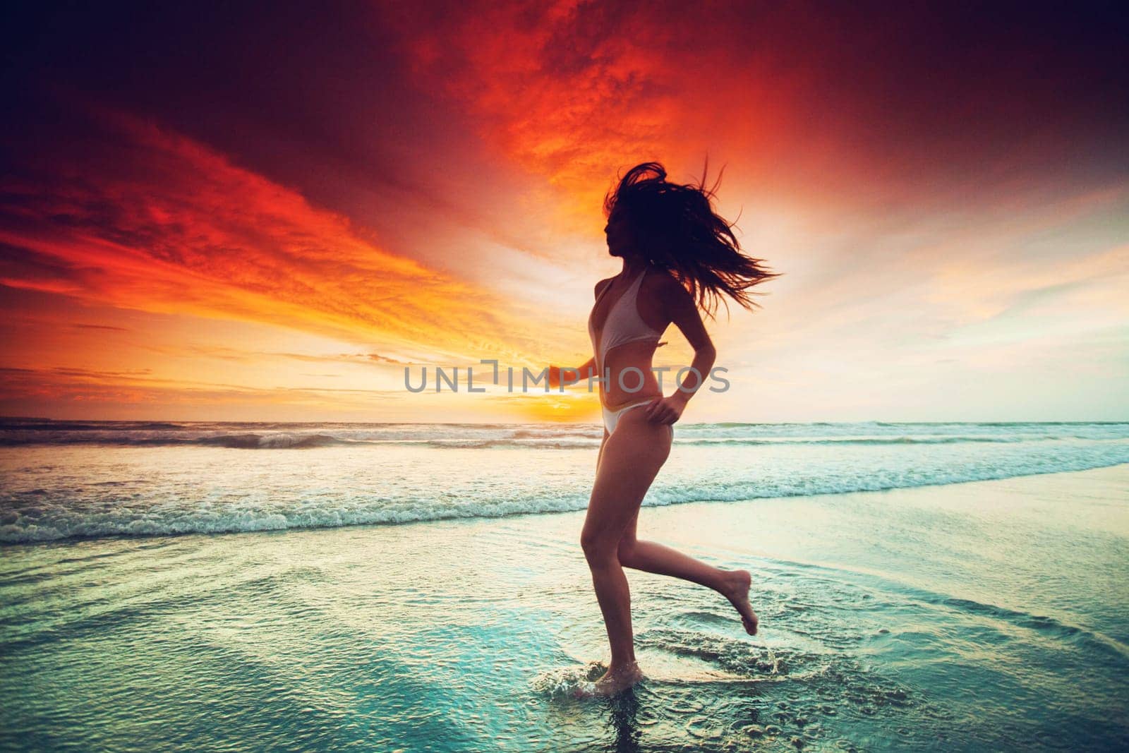 Happy woman running on the beach at sunset, Bali, Seminyak, Double six beach