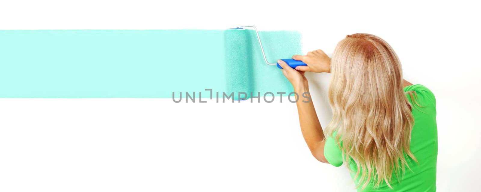 woman paints the wall brush