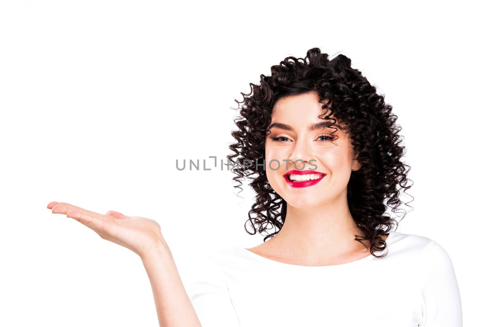 Portrait of amazing beautiful smiling woman with curly hair on white background showing copy space