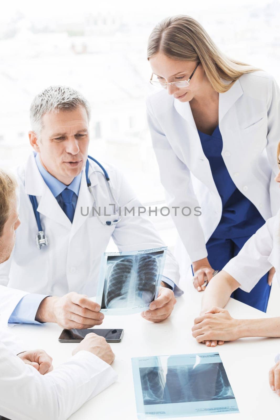 Group of doctors discuss x-ray by Yellowj