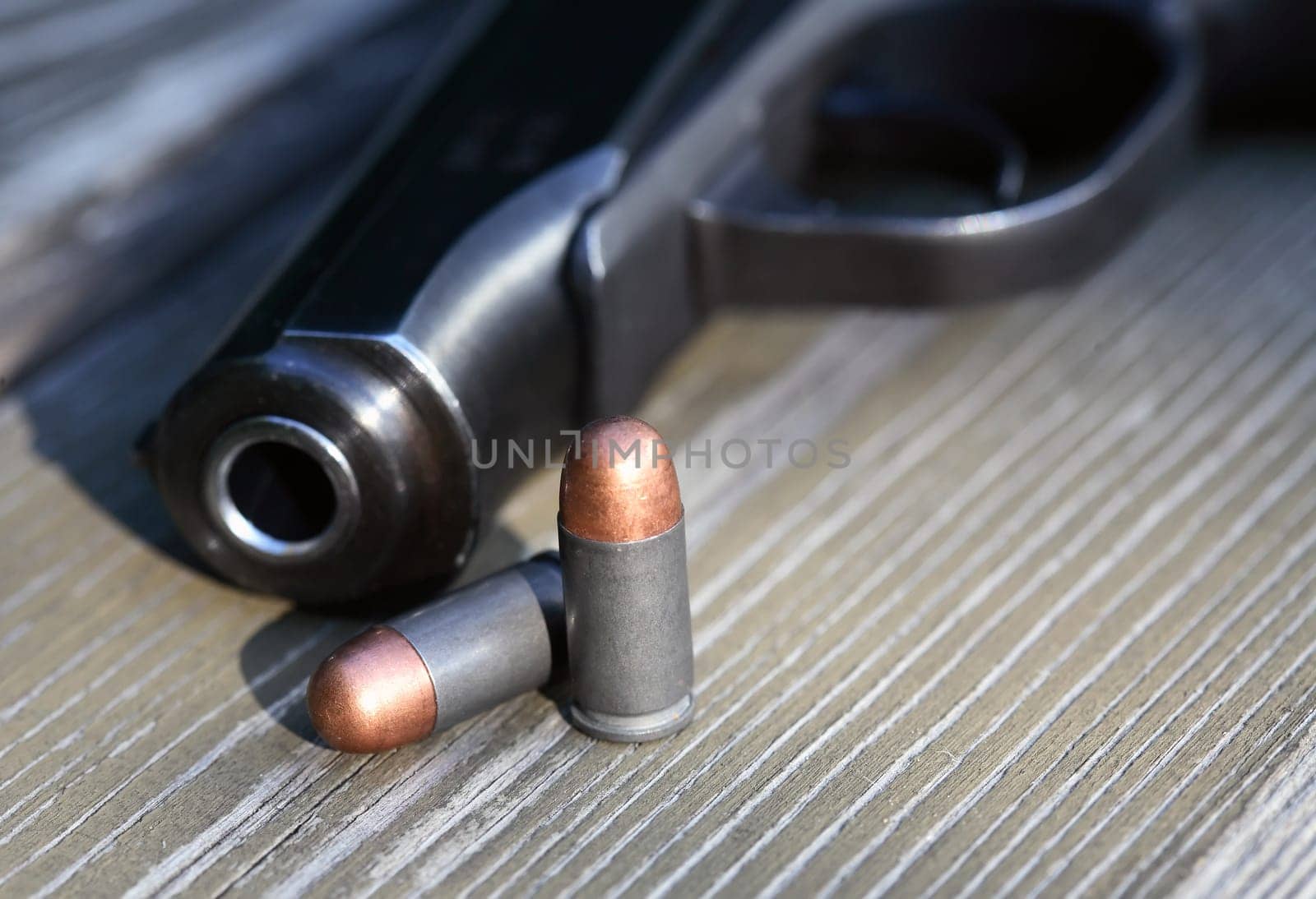 Handgun cartridges closeup on old wooden background near pistol