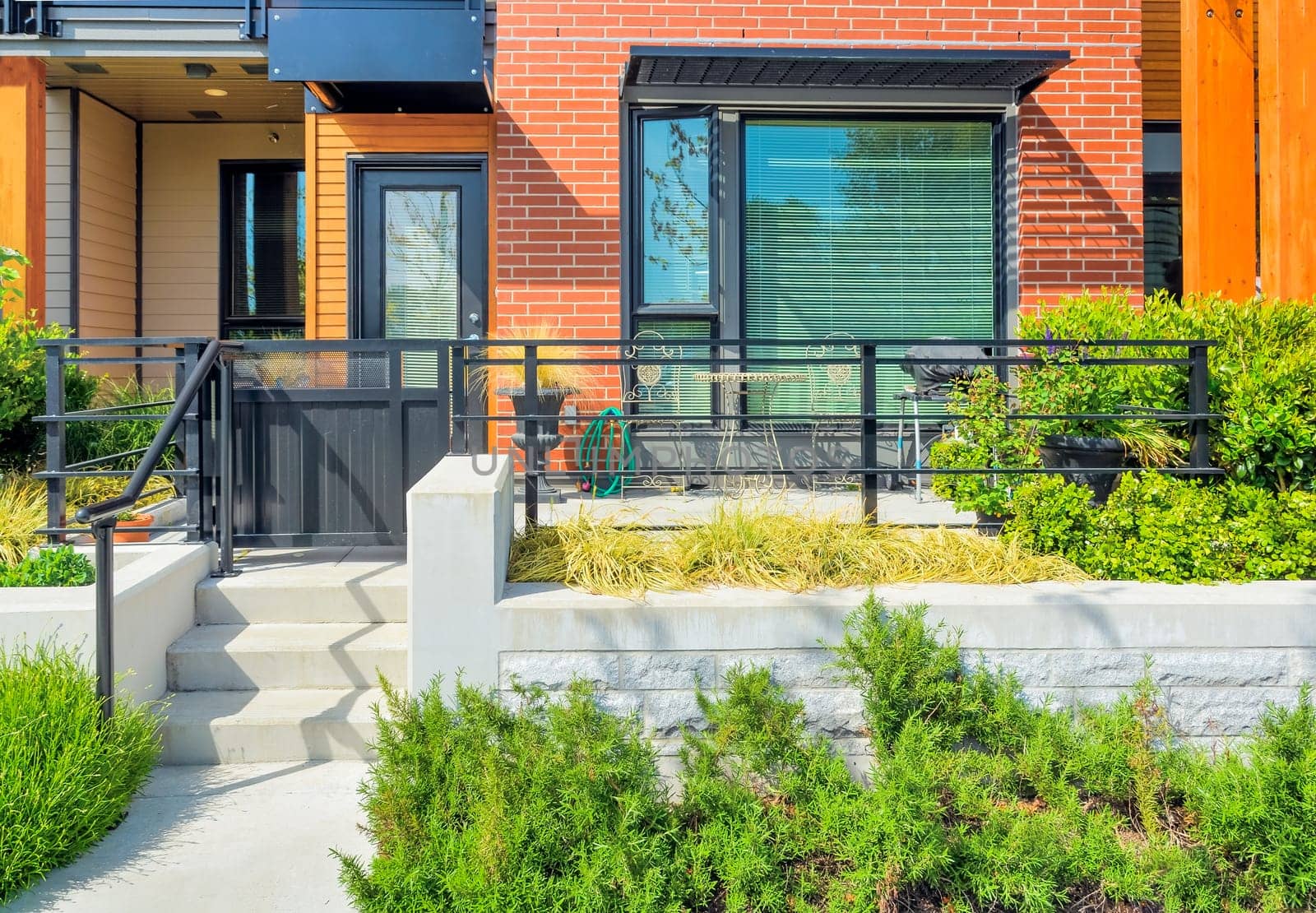 A perfect neighbourhood. Land terrace and small patio in front of private entrance to a residential unit in British Columbia