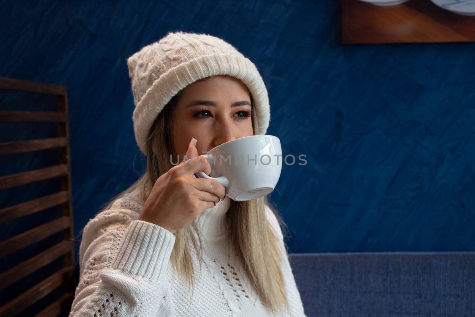 woman in white drinking coffee looking up. copy space. High quality photo