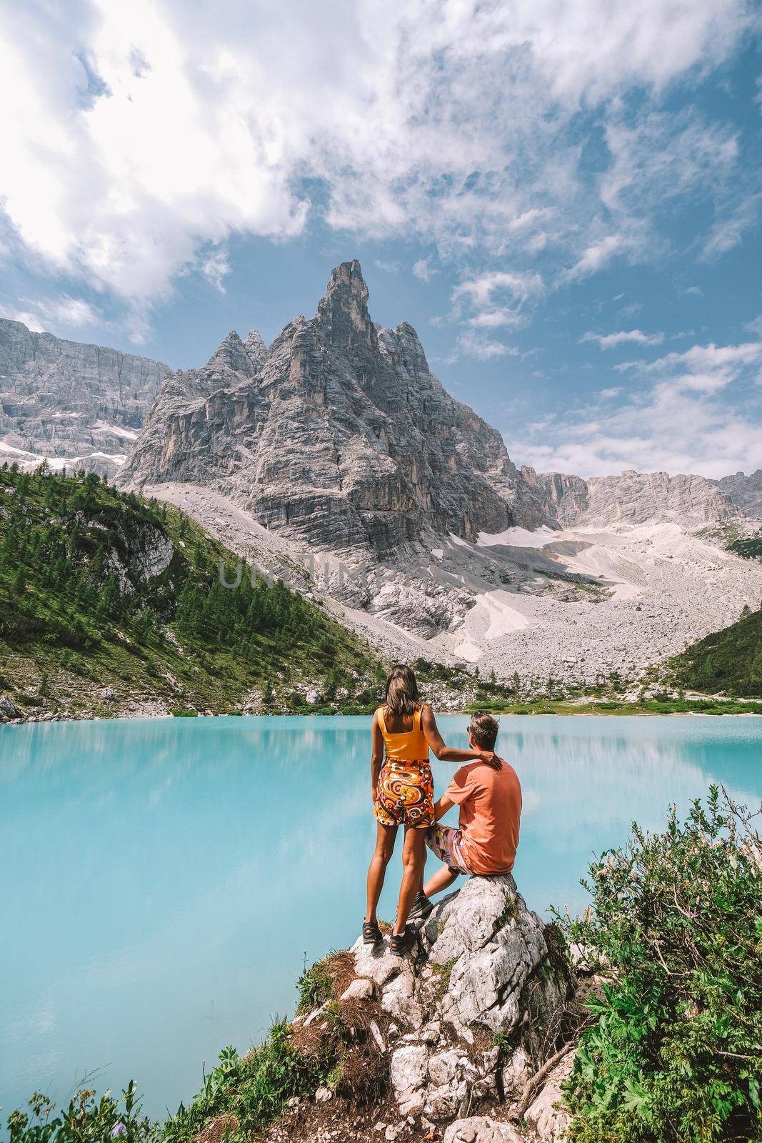 couple on vacation in the Italian Dolomites, Lago di Sorapis, Lake Sorapis, Dolomites, Italy. men and woman by the lake