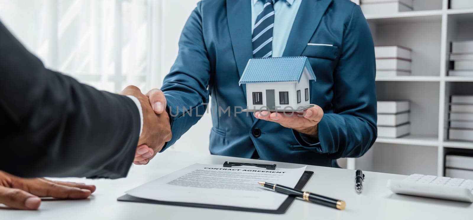 House model with agent and customer discussing for contract to buy, get insurance or loan real estate or property... by wichayada