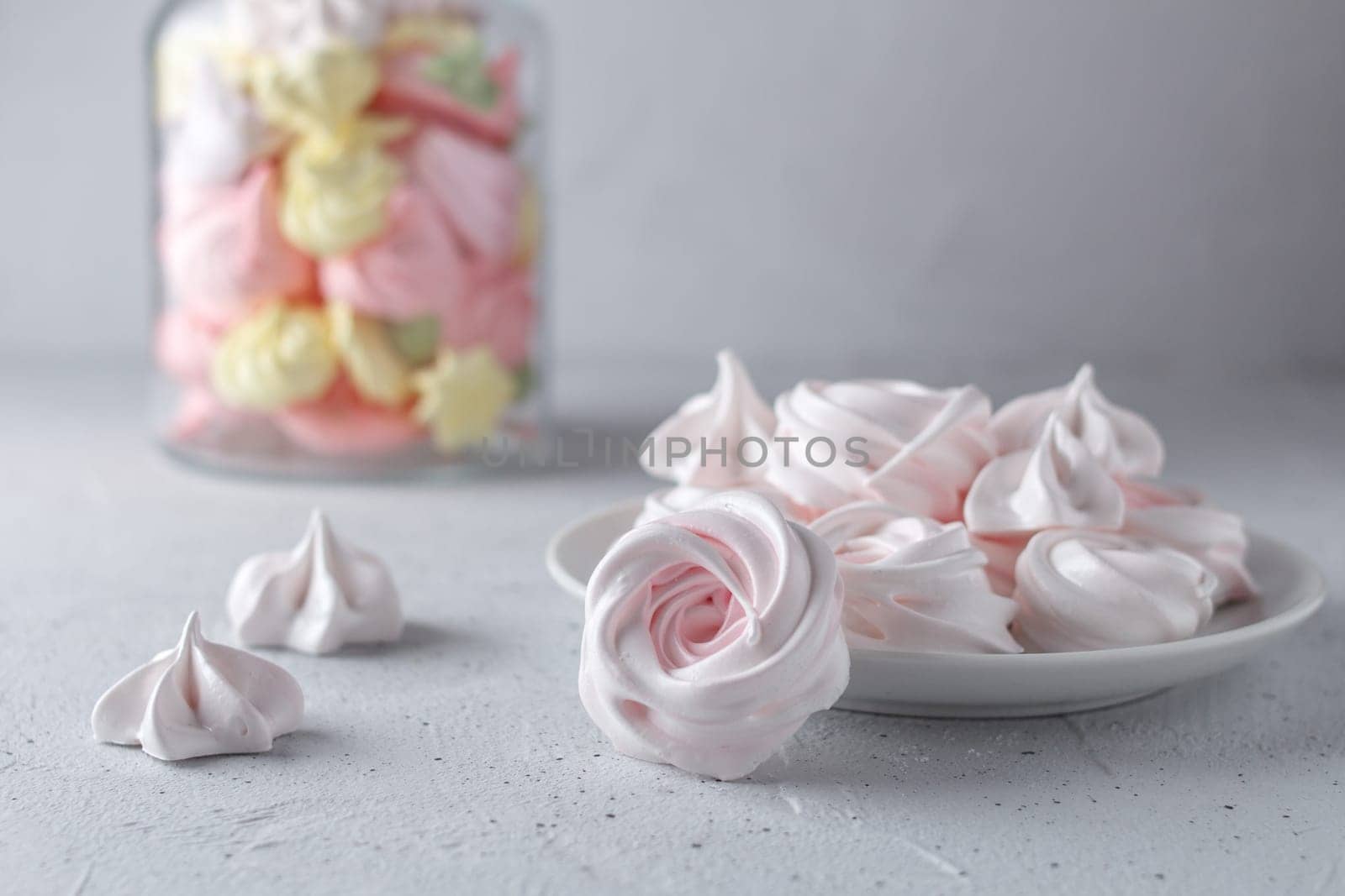 Meringue. Light dessert of whipped egg whites on a gray background.