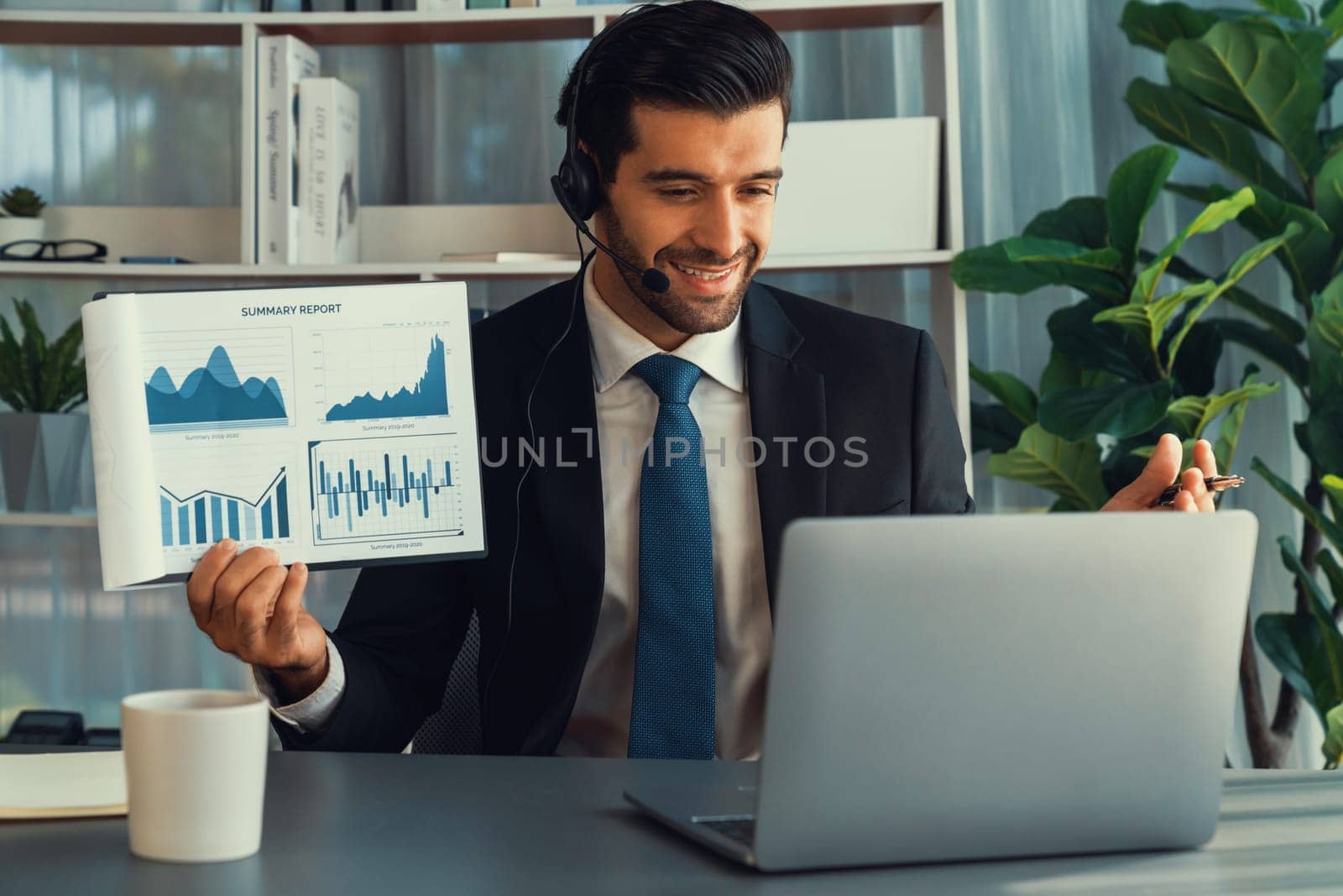 Business man wearing headphone present financial data or BI paper via laptop during online meeting. Remote work concept with virtual meeting presentation of effectiveness remote work. Fervent