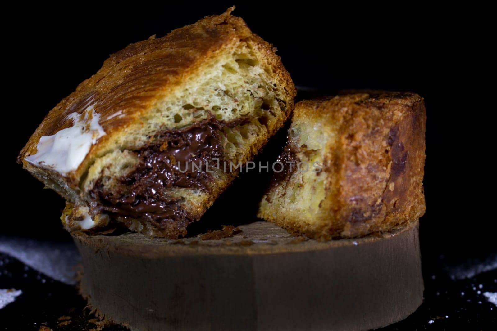 puff pastry filled with chocolate on a wooden platform. High quality photo