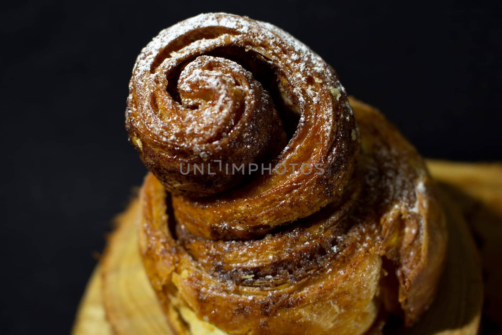 close-up of rustic puff pastry cake with swirled icing sugar. High quality photo