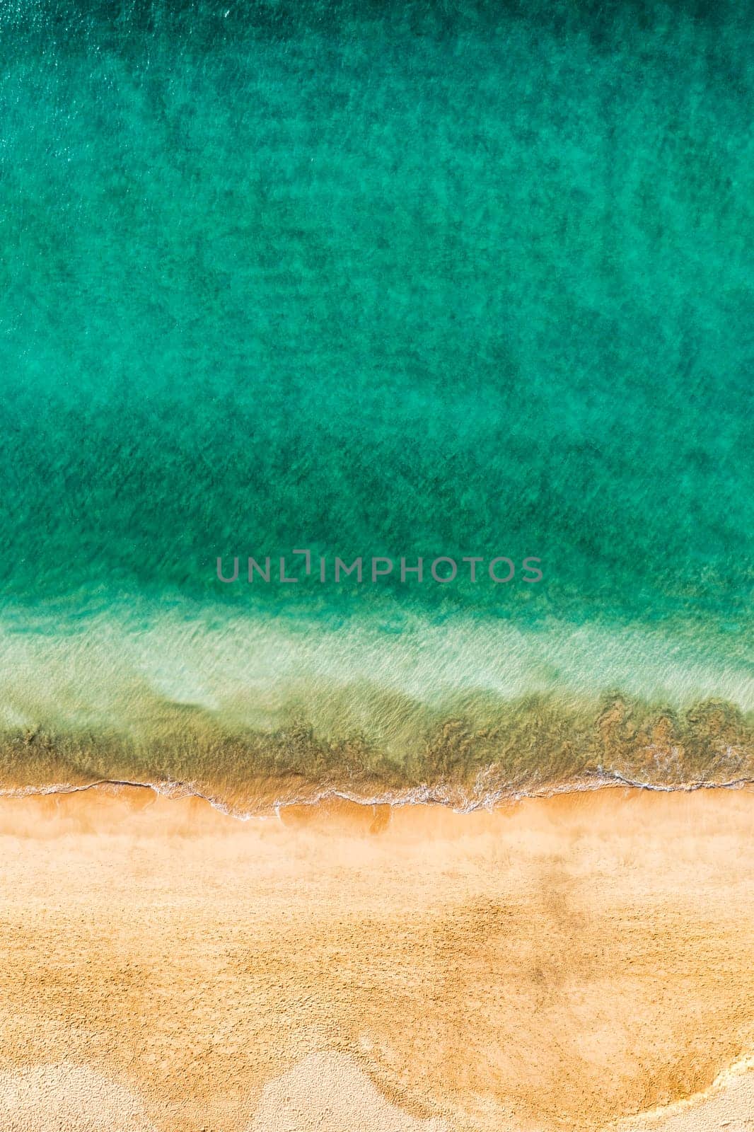 Beach with turquoise water on Fuerteventura island, Spain, Canary islands. Aerial view of sand beach, ocean texture background, top down view of beach by drone. Fuerteventura, Spain, Canary islands.