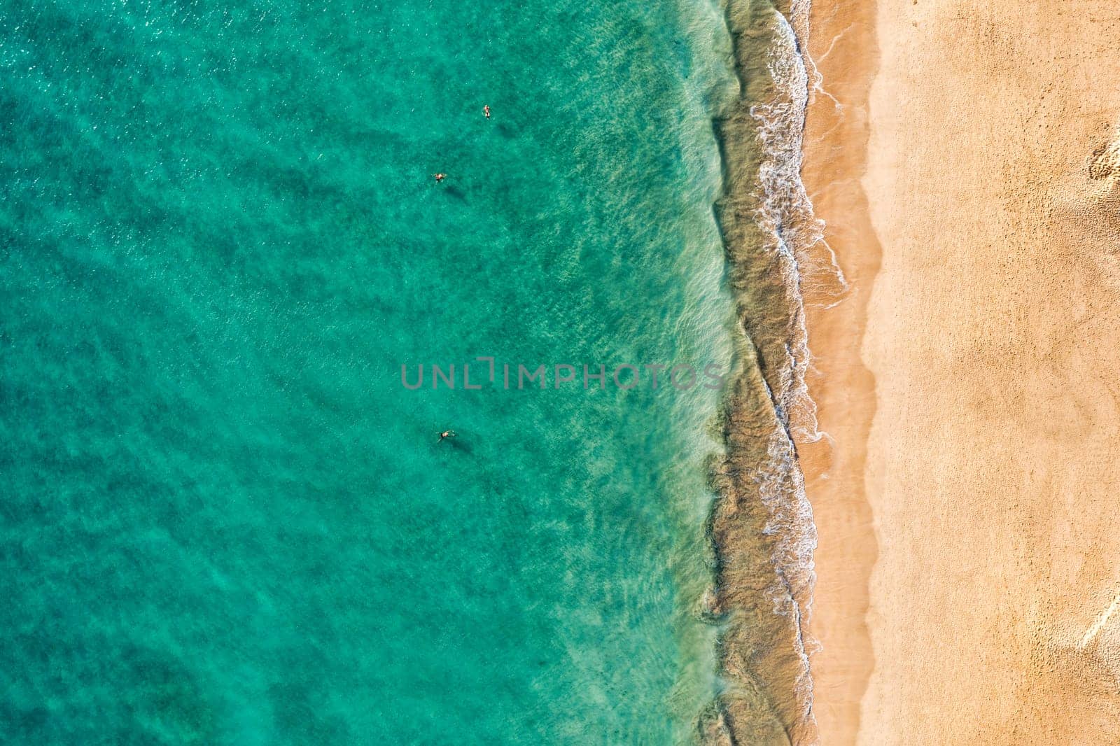 Beach with turquoise water on Fuerteventura island, Spain, Canary islands. Aerial view of sand beach, ocean texture background, top down view of beach by drone. Fuerteventura, Spain, Canary islands.