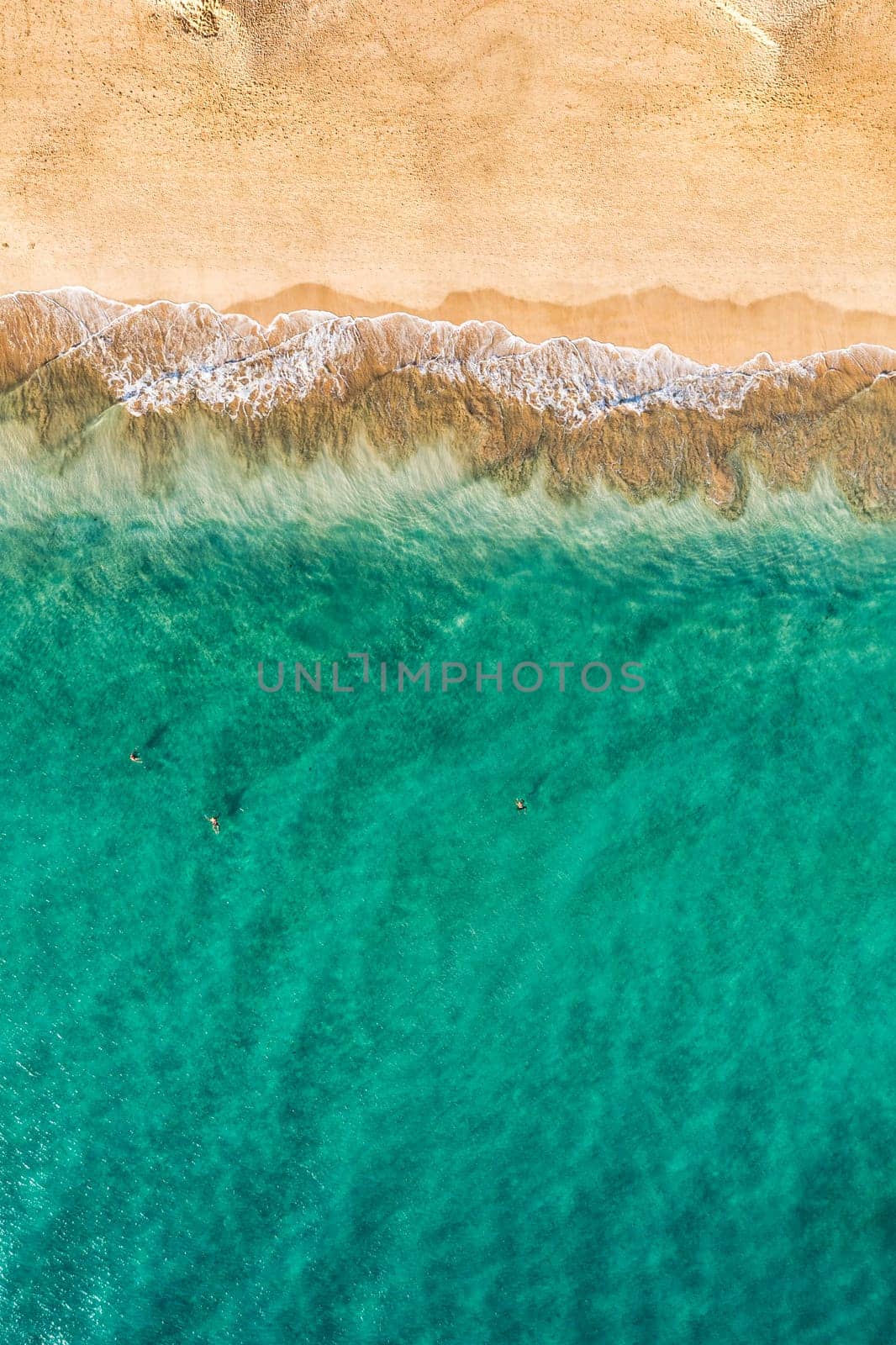 Beach with turquoise water on Fuerteventura island, Spain, Canary islands. Aerial view of sand beach, ocean texture background, top down view of beach by drone. Fuerteventura, Spain, Canary islands.