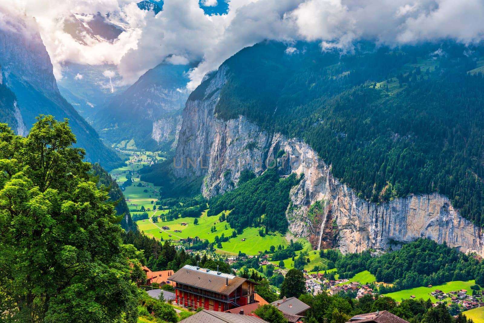 Amazing summer landscape of touristic alpine village Lauterbrunnen with famous church and Staubbach waterfall. Location: Lauterbrunnen village, Berner Oberland, Switzerland, Europe.