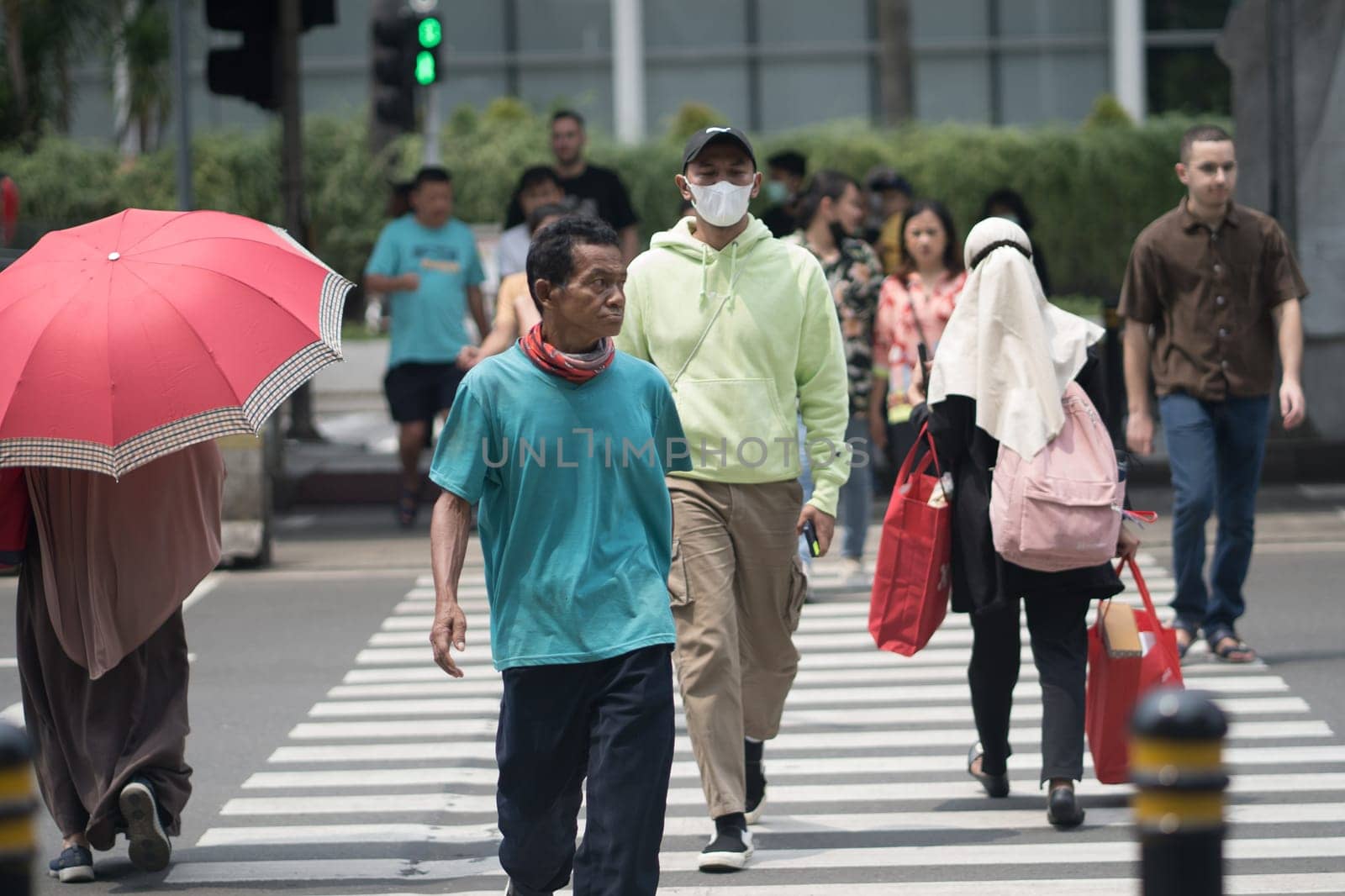 April 20, 2023. People crossing from the Transjakarta Bus Shelter. Jakarta, Indonesia. Street Photography.