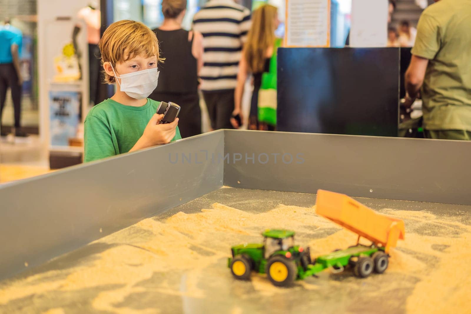Adorable cute little child playing with toy on remote control, in the mall. Happy kid boy having fun. Leisure, lifestyle for kids concept.