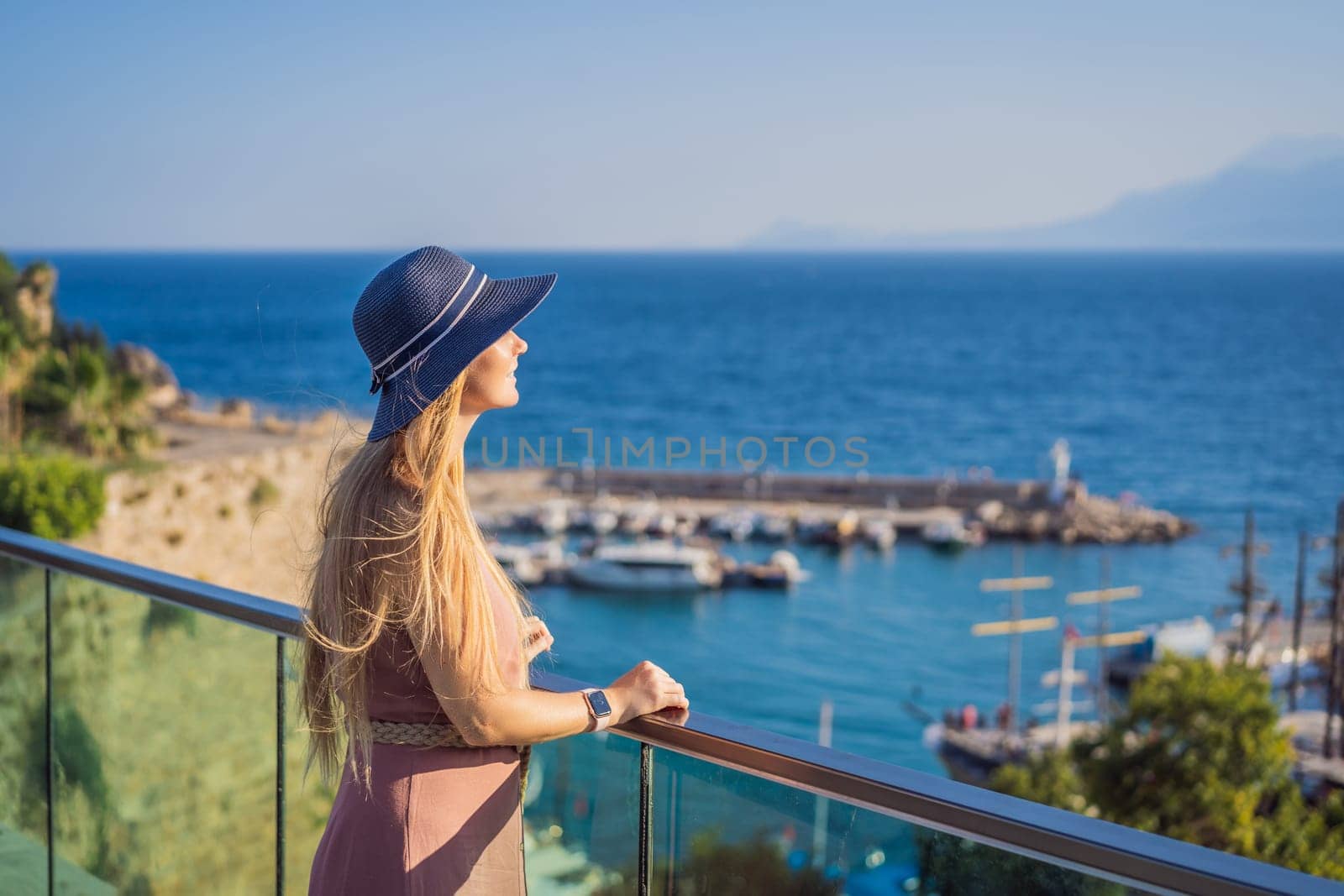 Woman tourist in Old town Kaleici in Antalya. Turkiye. Panoramic view of Antalya Old Town port, Taurus mountains and Mediterrranean Sea, Turkey.