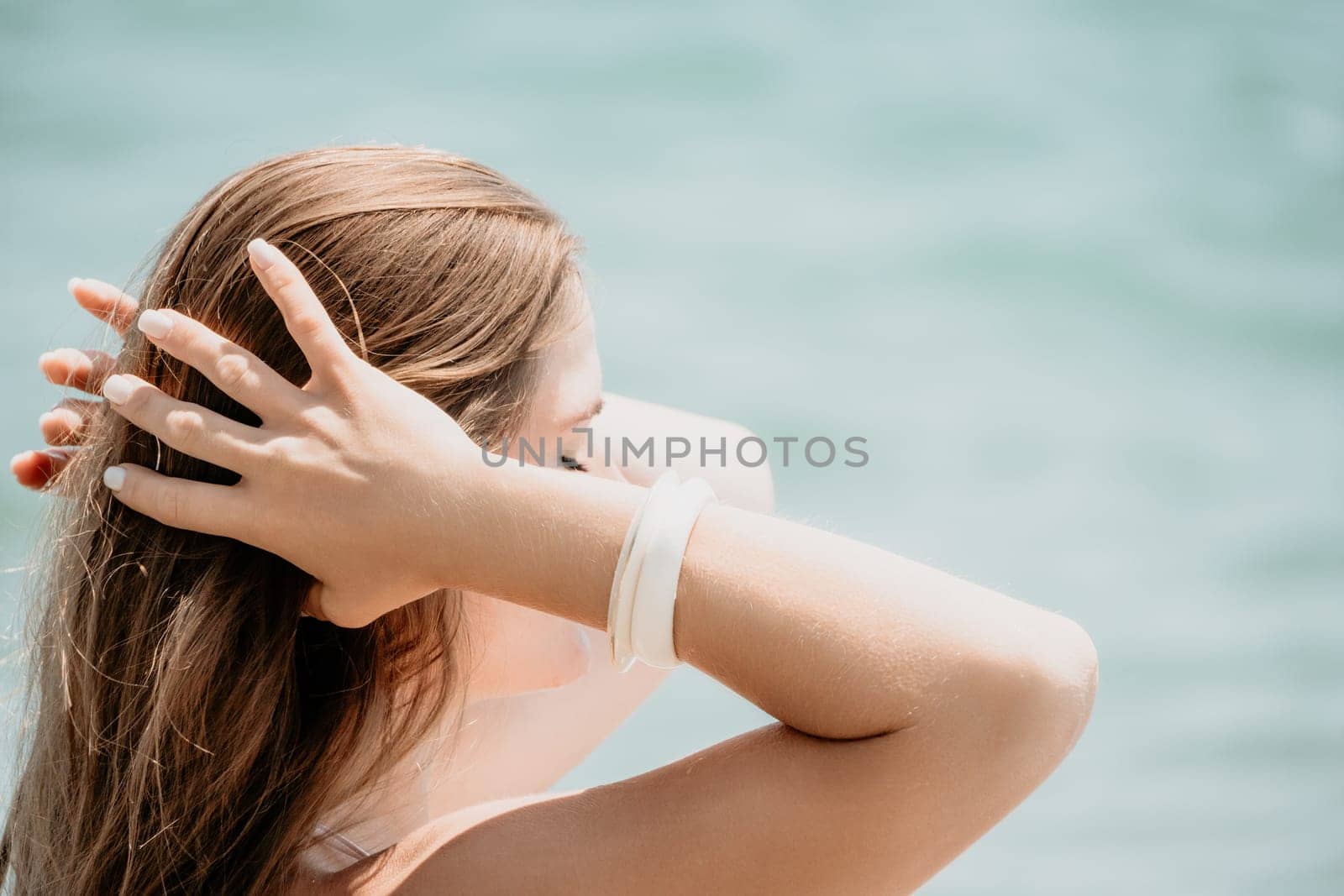 Close up Yoga Hand Gesture of Woman Doing an Outdoor meditation. Blurred sea background. Woman on yoga mat in beach meditation, mental health training or mind wellness by ocean, sea by panophotograph