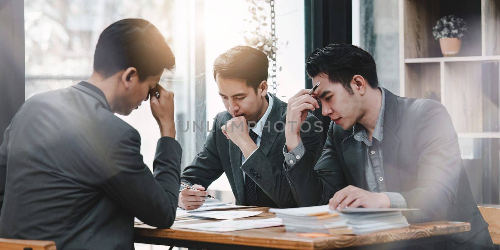 Stressed business person working and research strategy on laptop and looking worried, tired, finance, teamwork, Big data Graphs Charts concept by itchaznong