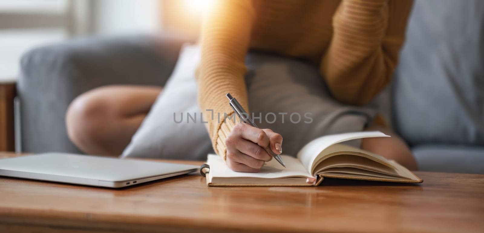 Close up of female hands who write in a notebook. Work at home..