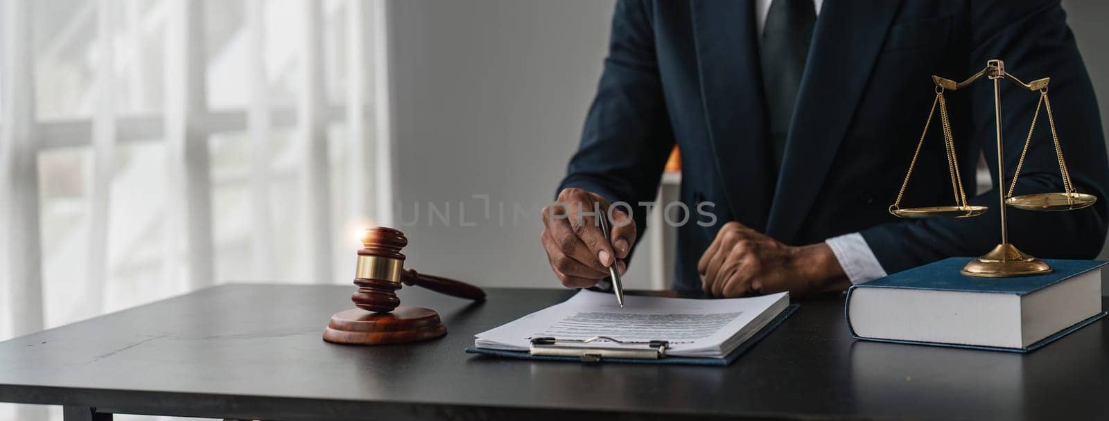 Close up lawyer businessman working or reading lawbook in office workplace for consultant lawyer concept. by wichayada