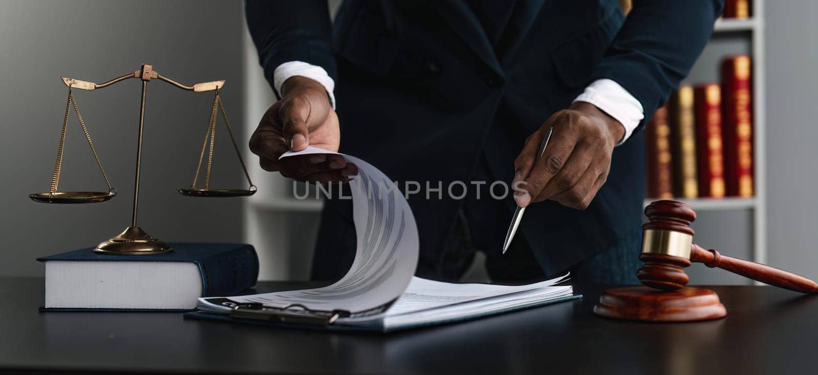 Close up lawyer businessman working or reading lawbook in office workplace for consultant lawyer concept. by wichayada