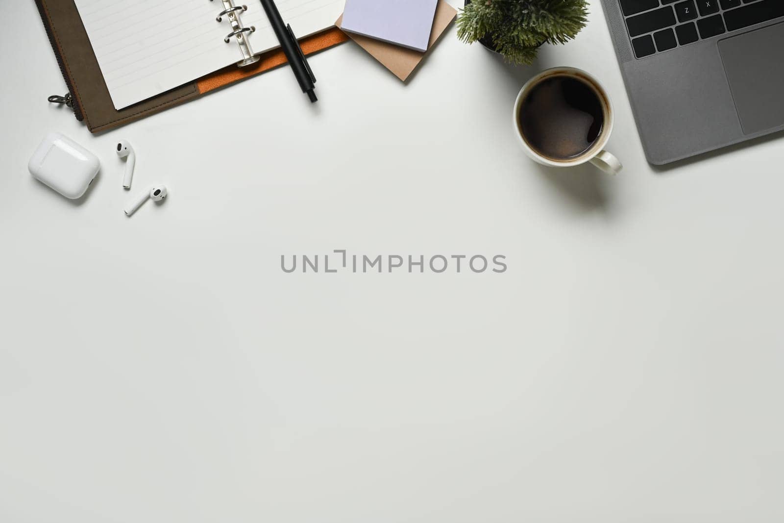 Modern white office desk table with laptop computer, cup of coffee and notebook. Top view with copy space, flat lay. by prathanchorruangsak