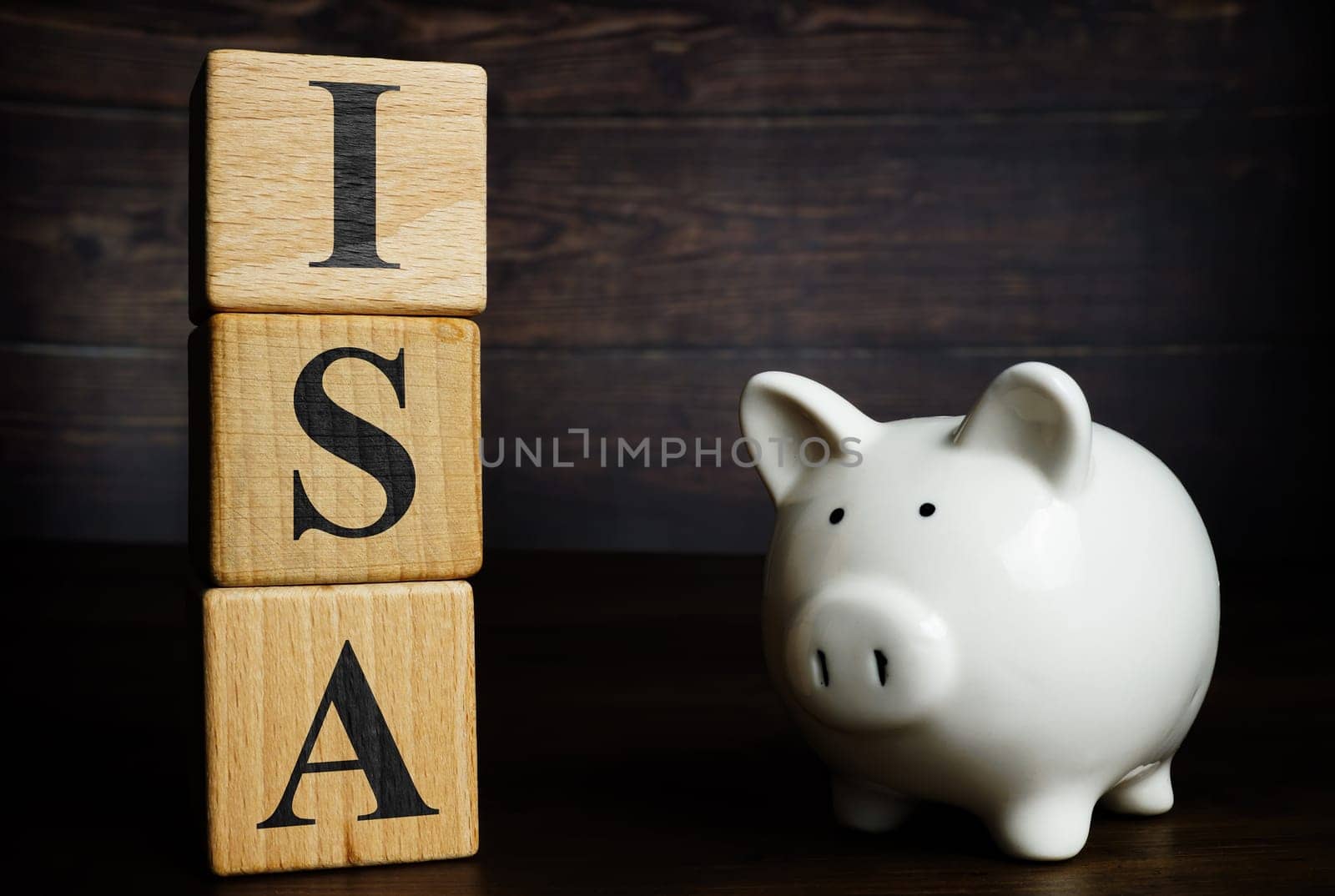 Wooden cubes with letters and piggy bank ISA Individual Savings Account. by designer491