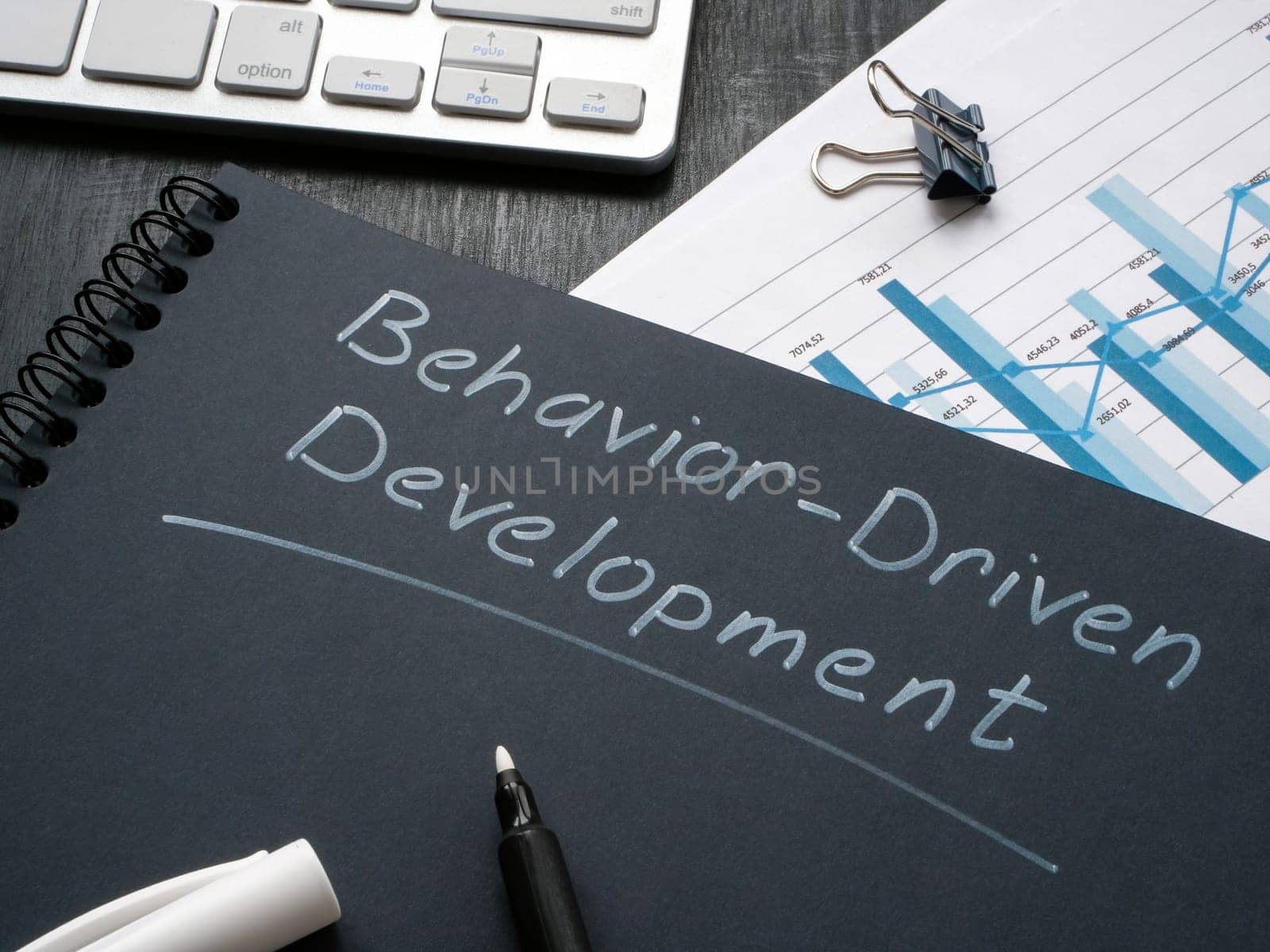 Desk with notepad and marks about behavior driven development BDD. by designer491