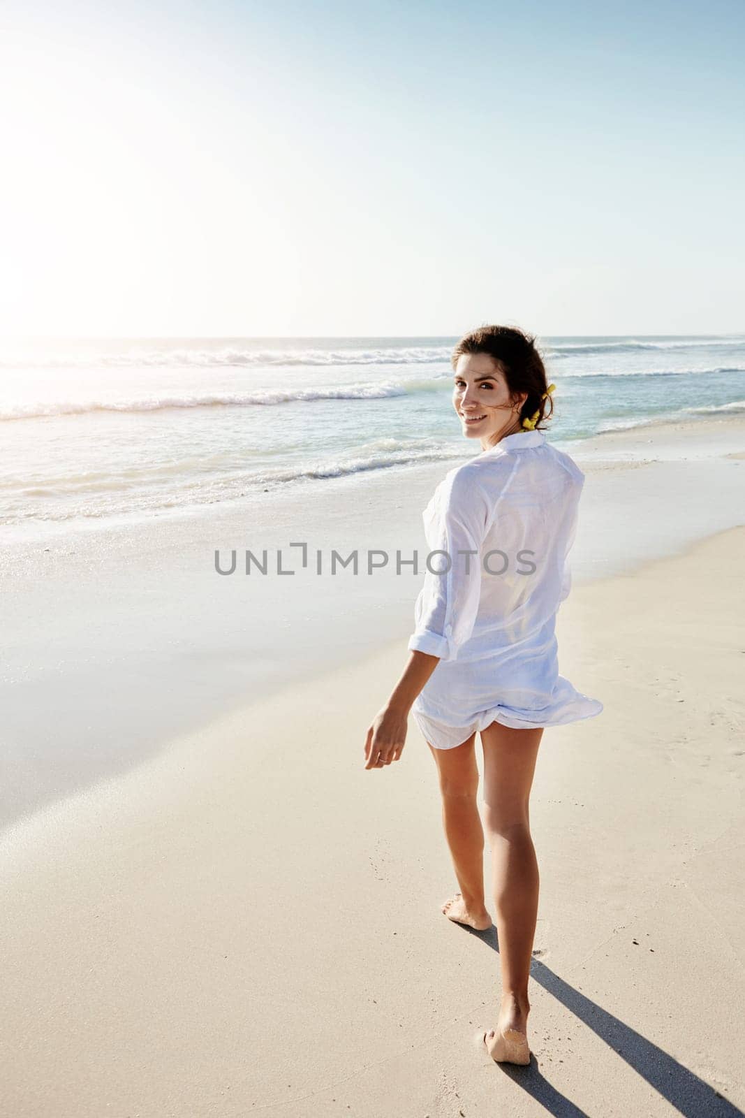 Romance me with walks on the beach. a beautiful young woman enjoying her day at the beach. by YuriArcurs