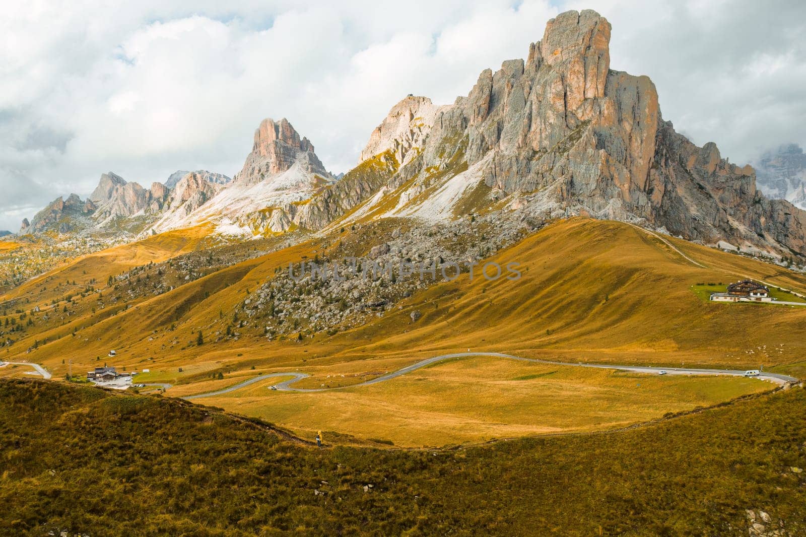 A lofty mountain range covered by clouds on the slopes of the famous Giau Pass.
