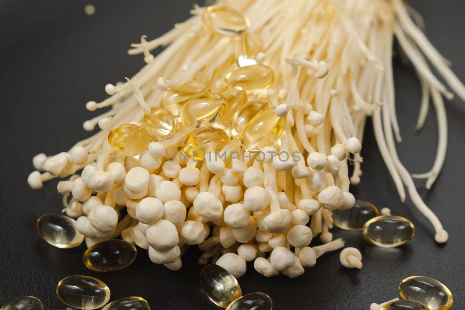 Mushroom or enoki close up, enokitake Flammulina velutipes. Capsules, dietary supplements.