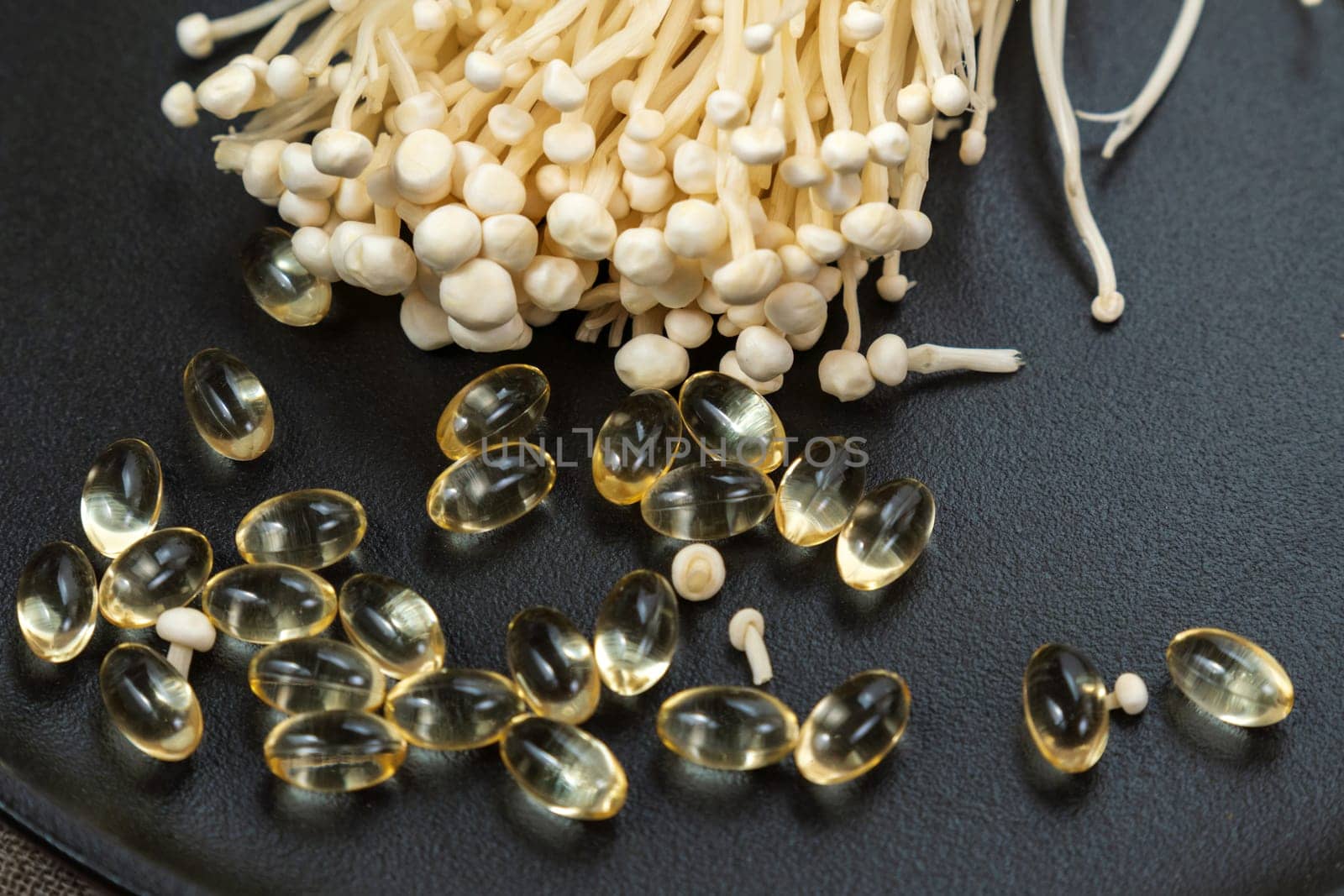 Mushroom or enoki close up, enokitake Flammulina velutipes. Capsules, dietary supplements. by darksoul72