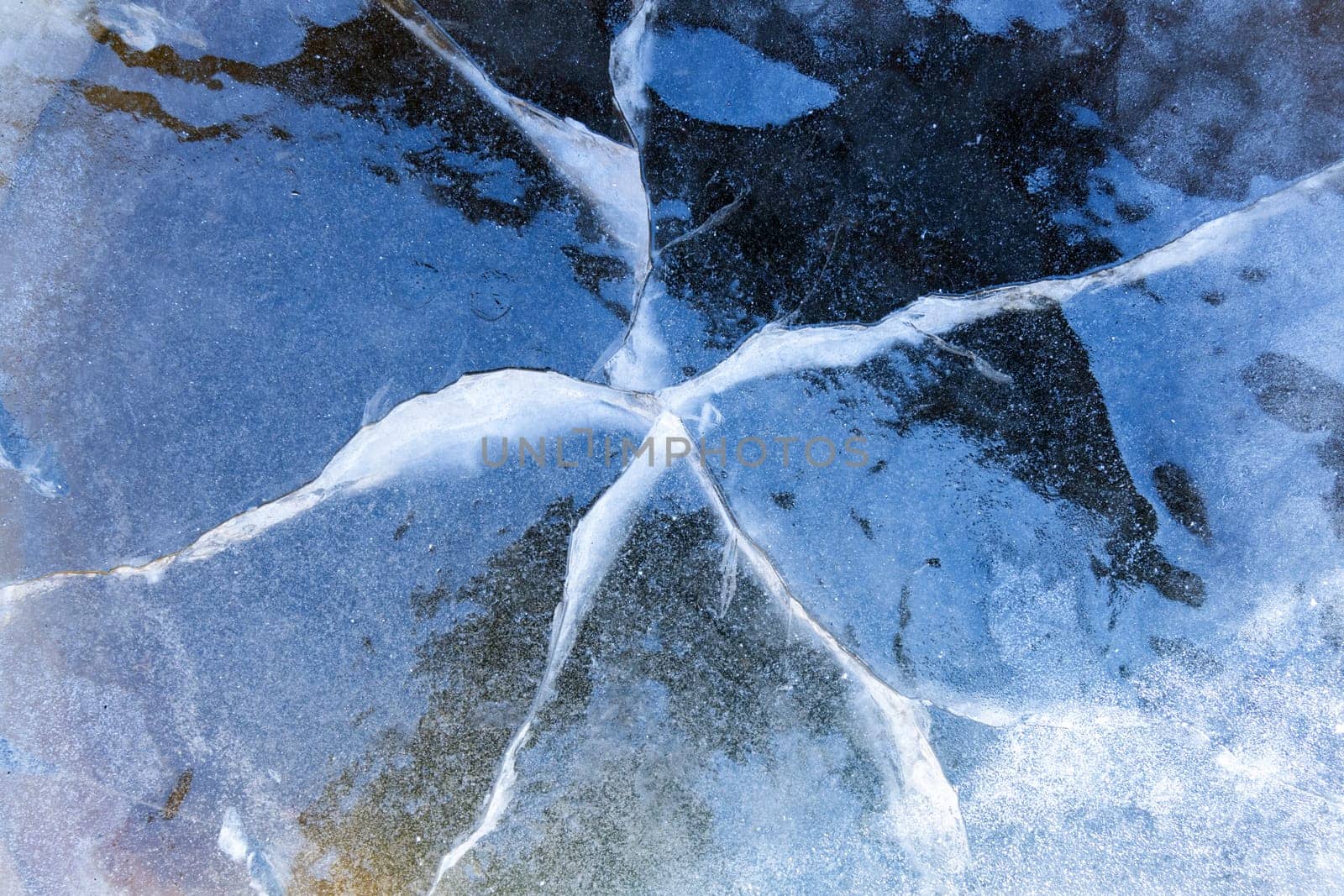 Cracked ice texture. Frozen lake water in winter. Selective focus