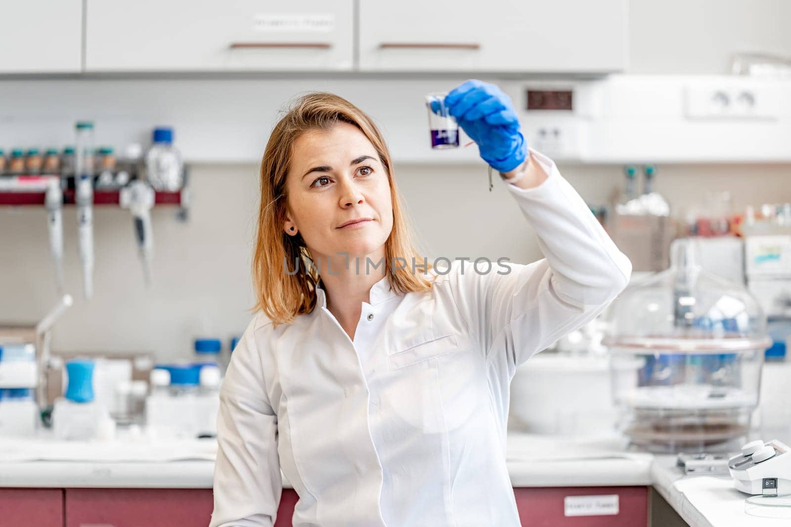 a scientist examines chemically sample of a new drug in a research laboratory by Edophoto