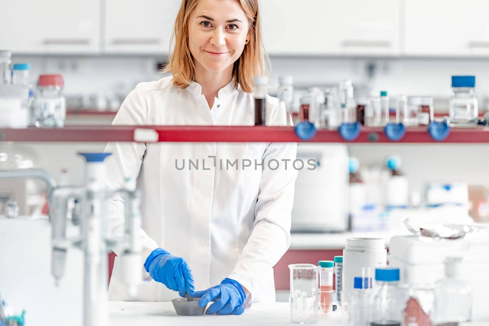 a female student at the science faculty of the university conducts biochemical research in the laboratory by Edophoto