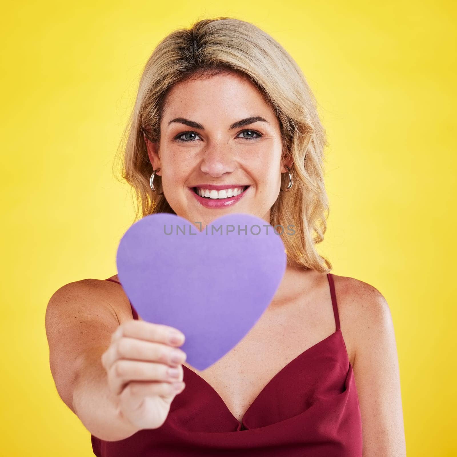 Portrait, heart and woman with wellness, emoji and happiness against a studio background. Face, female model and happy lady with a symbol for love, sign and support with smile, romantic and care by YuriArcurs