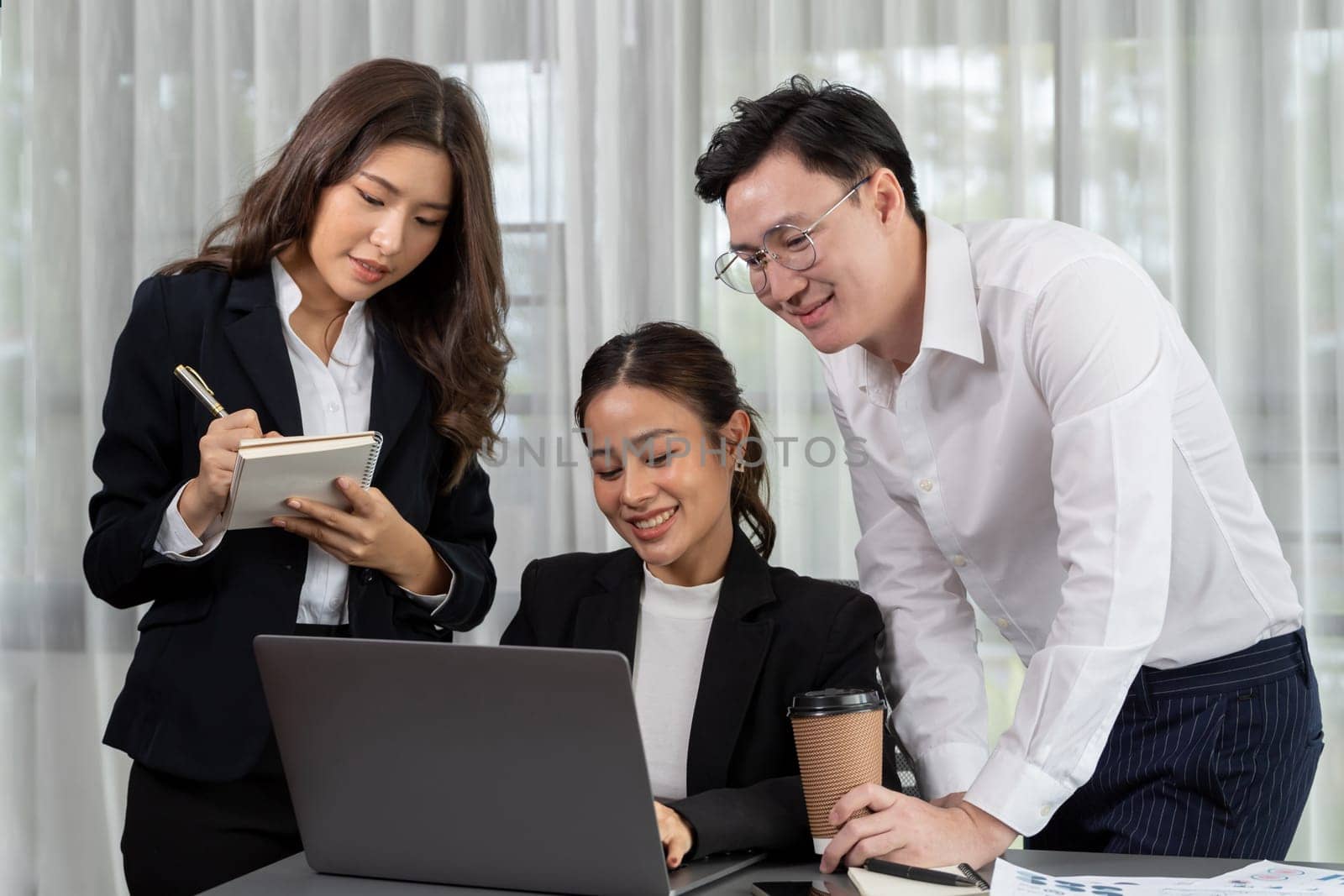 Harmony in office concept as business people analyzing dashboard paper together in workplace. Young colleagues give ideas at manager desk for discussion or strategy planning about project.