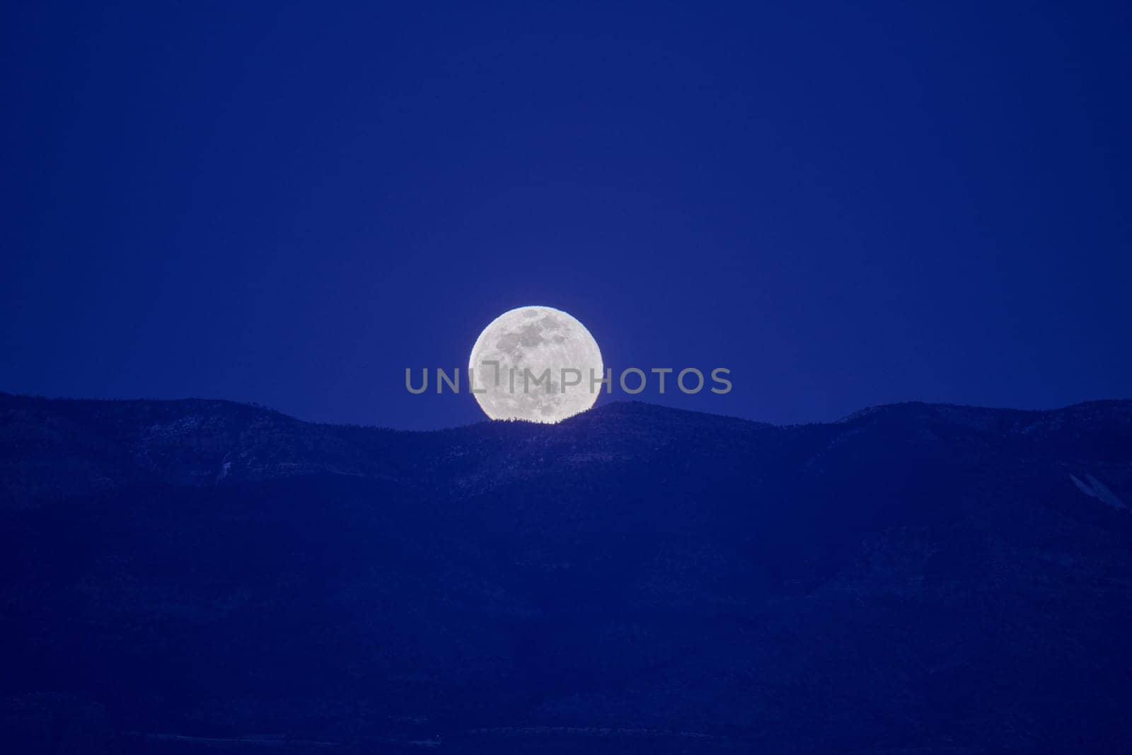 Full moon rising over Sierra Ancha Range. by patrickstock