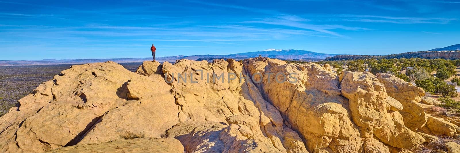 Woman standing on top of sandstone formations at El Malpais National Monument, New Mexico.