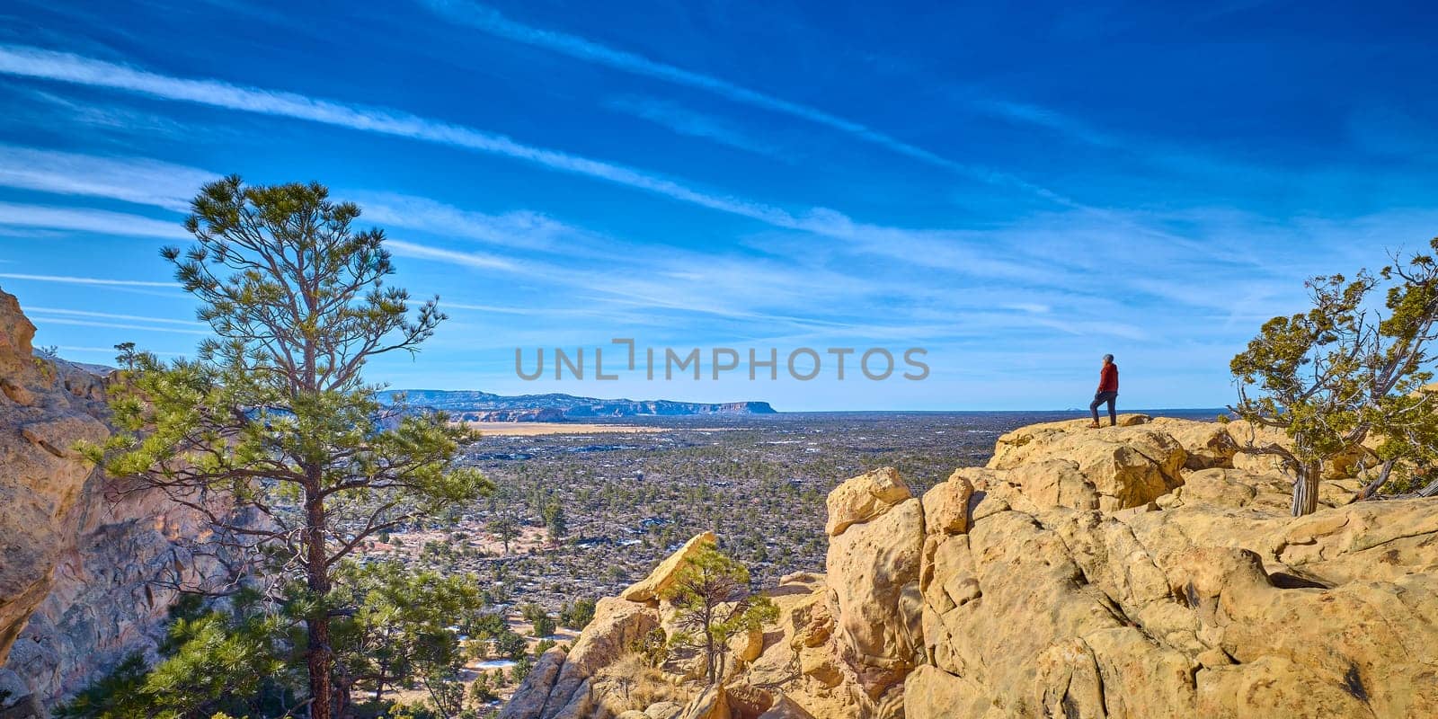 Woman stand at the edge of the sandstone cliffs at El Mapais National Monument, New Mexico. by patrickstock