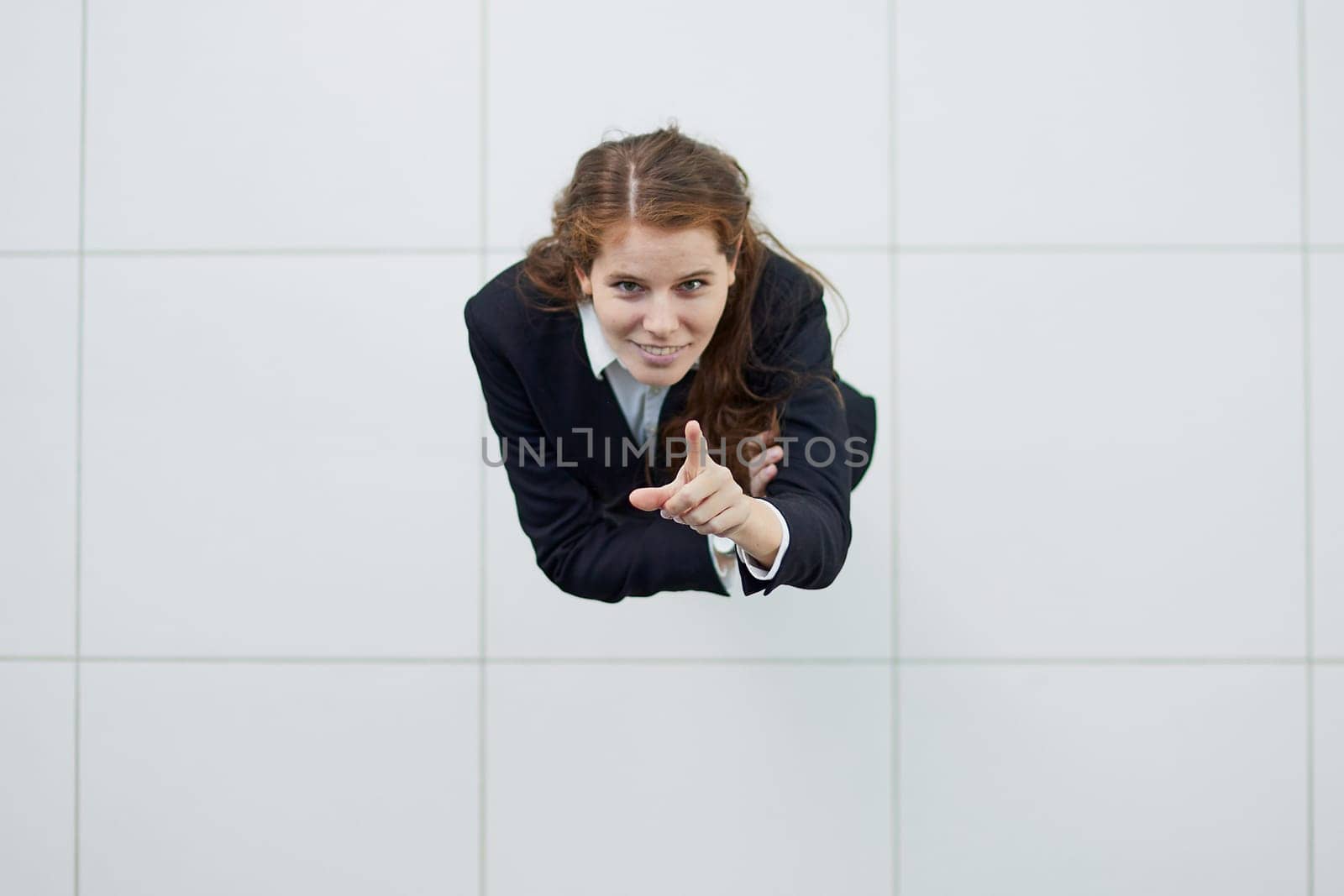Portrait of a smiling girl with arms crossed from above